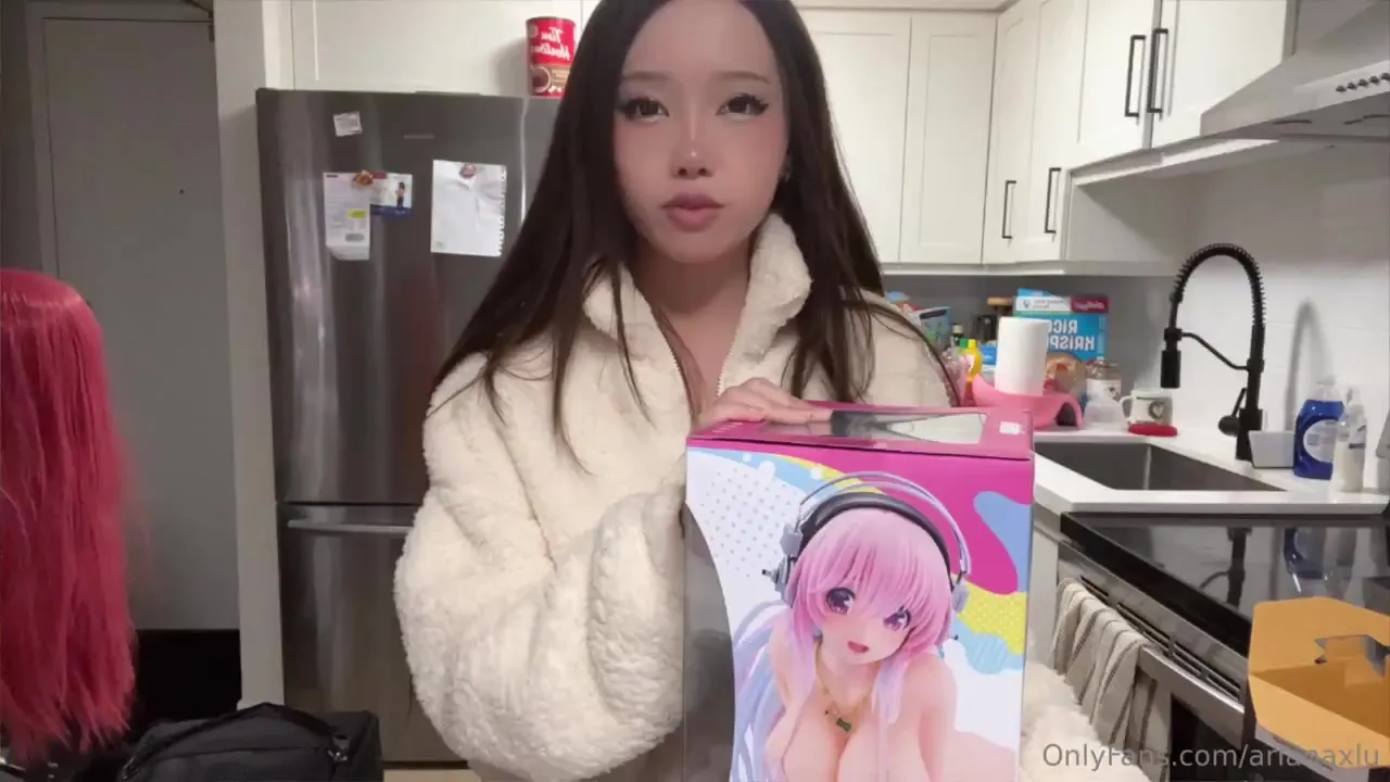 Ari_n3ko unzips her fleece and grins at the busty pink-haired figure