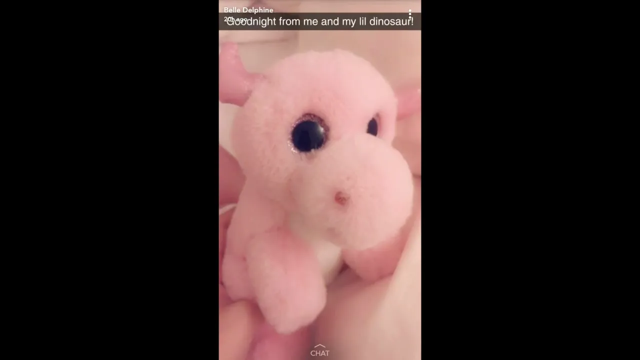 Rainy afternoon, Belle Delphine sprawls on the bed in black lingerie, playing with her pink dino plush