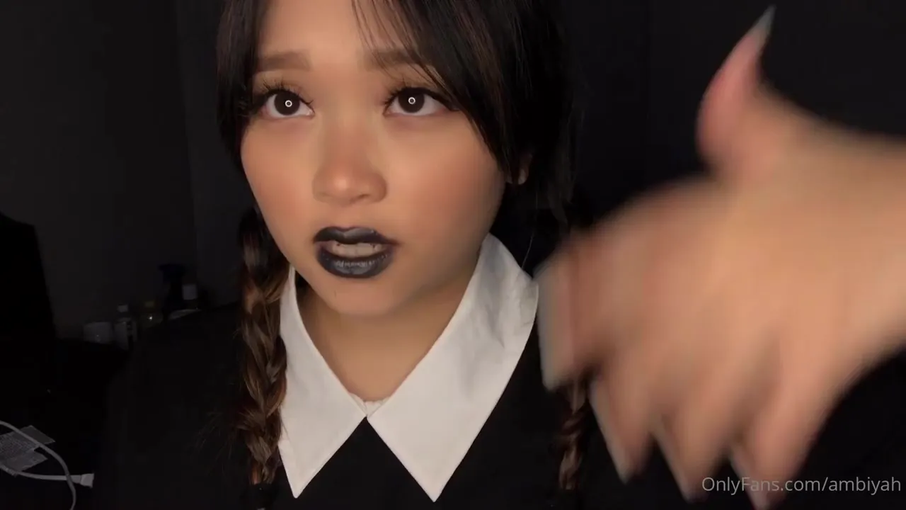 Mae in black lipstick and twin braids, playing the naughty schoolgirl for you