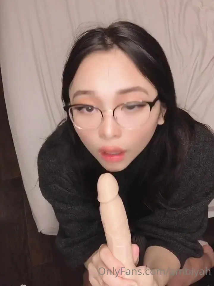 Candynxtdoor sucks a toy cock hungrily in bed, glasses still on