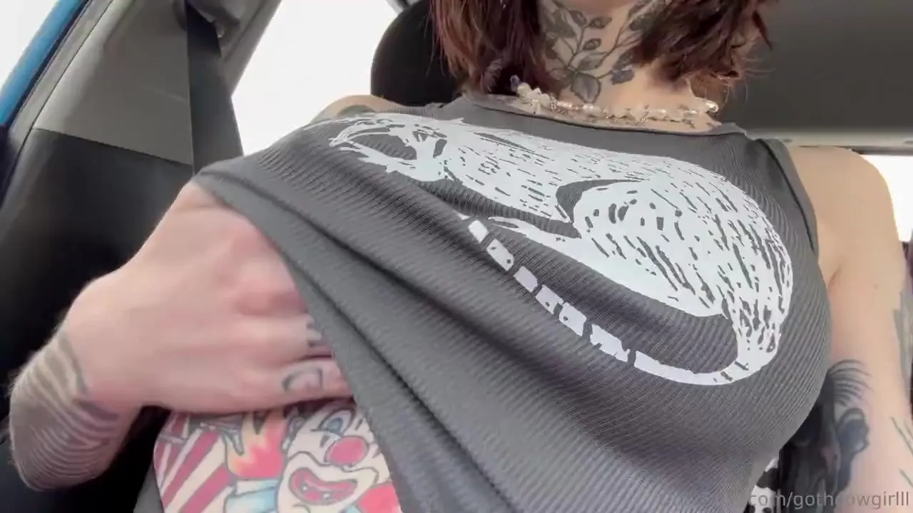 Tugging her tank top up and flashing her pierced tits while sitting in the car
