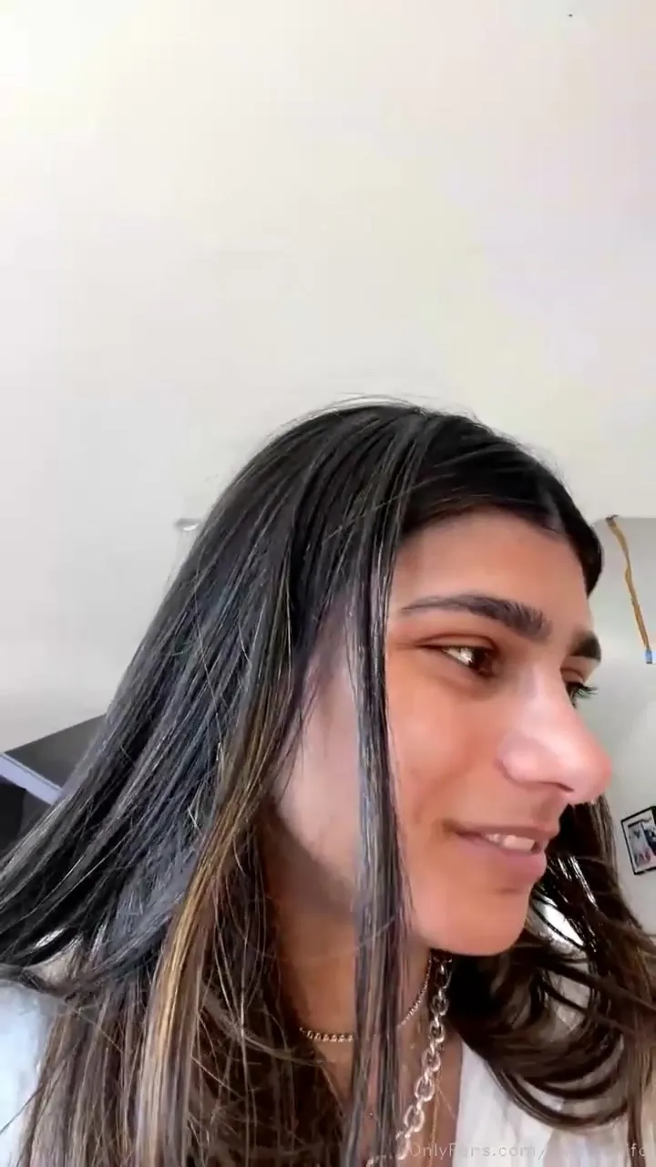 Laughing and giggling on the couch, Miakhalifa tugs her hair back with both hands