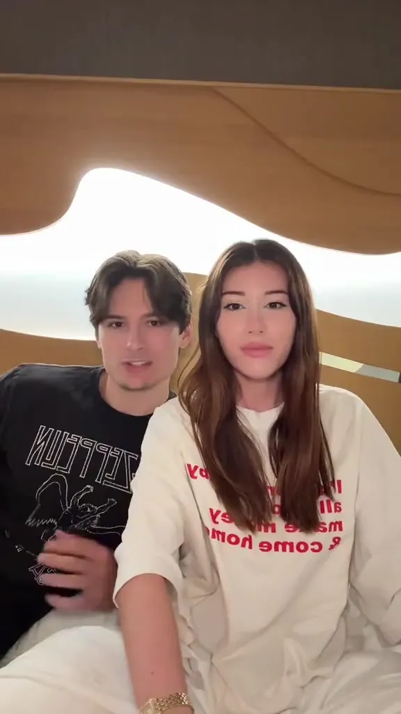 In a loose white tee, Mikaela Testa sprawls out and chats with her man