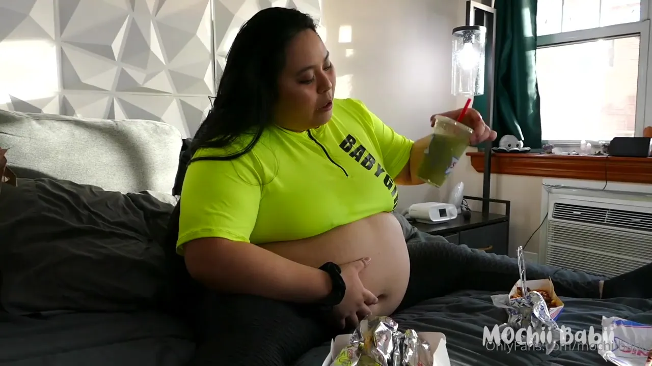 Mochiibabii lies back and devours burgers, belly bare and full