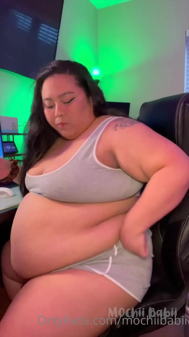 Lifting her top in the gaming chair, Mochii Babii bares her belly and rolls her tongue