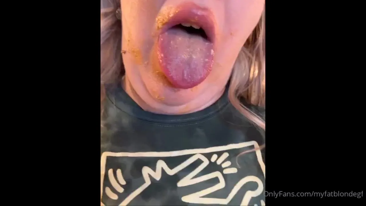 MyFatBlondeGirlfriend in a green camo crop top, dunking a sandwich in cheese and smearing it all over her face