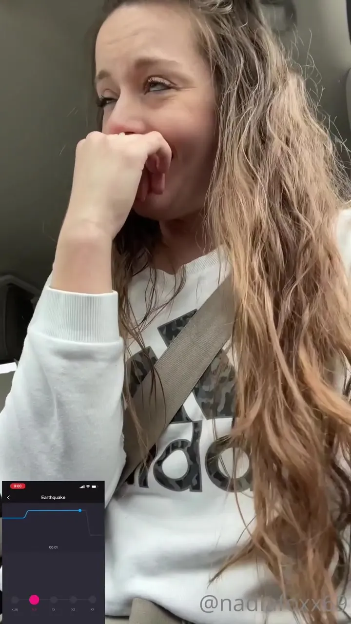 Nadia Foxx giggles in the passenger seat while the quake app shakes