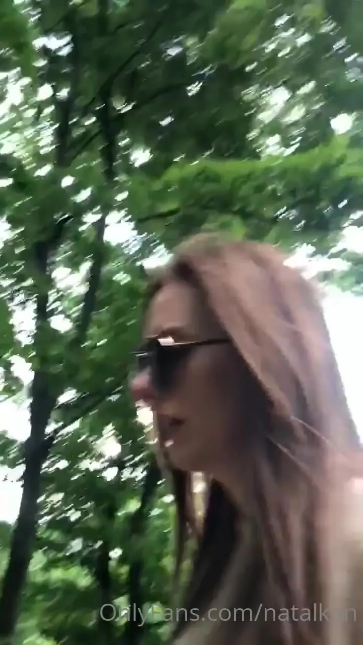 Zdarma Odber strolling the green park path, sunglasses on and lips parted, looking back hungry