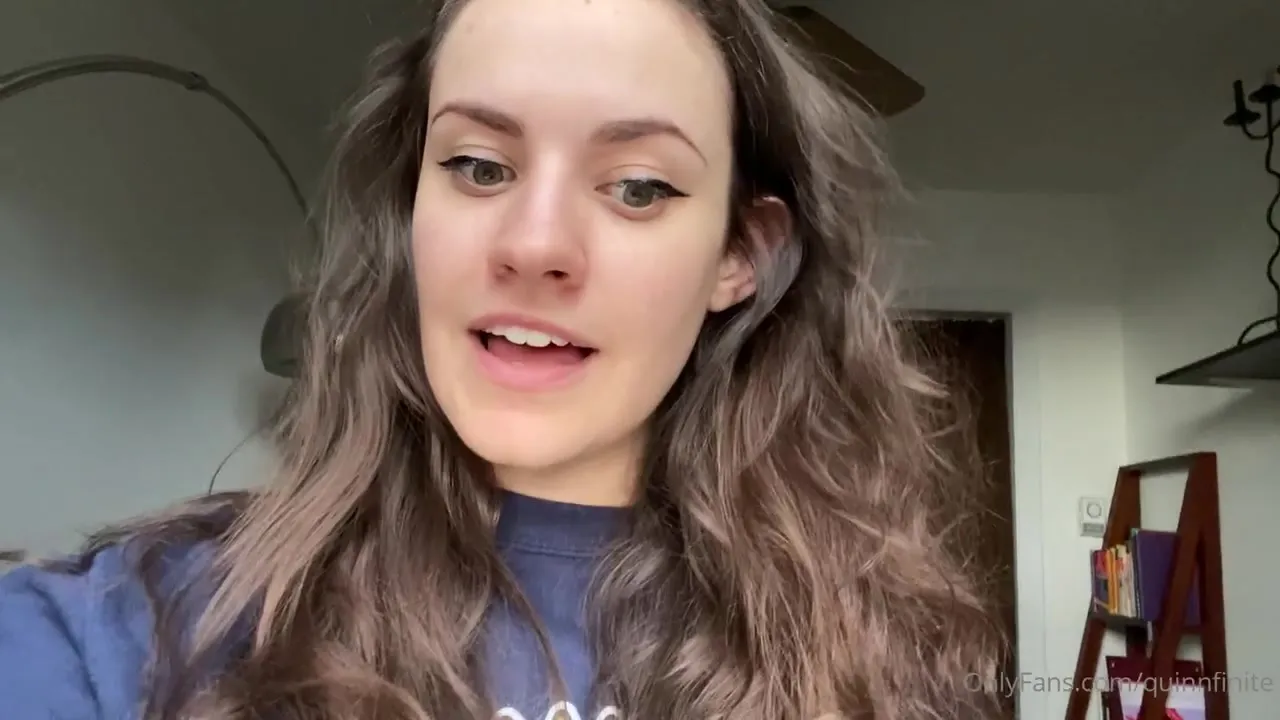Sitting in a blue sweatshirt, Quinn Finite stares back with wide green eyes