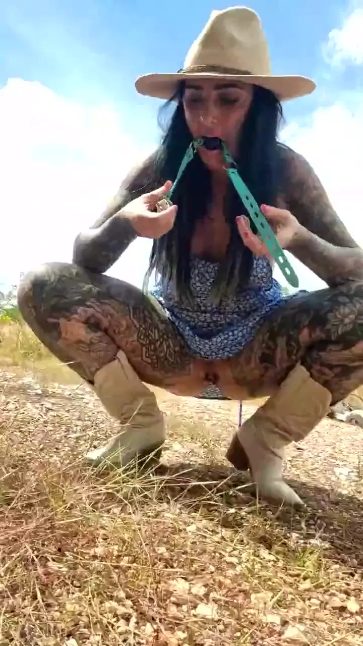 In the dirt in cowboy boots, muddy flips her romper and bares her tattooed ass