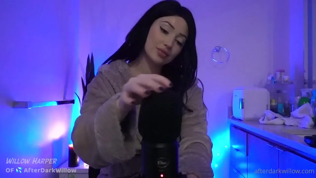 Willow Harper fiddles with a fuzzy mic cover in her blue-lit kitchen