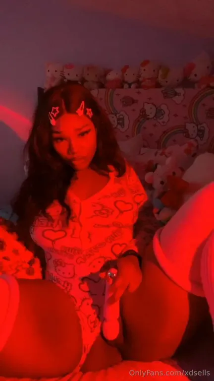 Working a pink toy deep inside her pussy, Nye Lt moans under red light