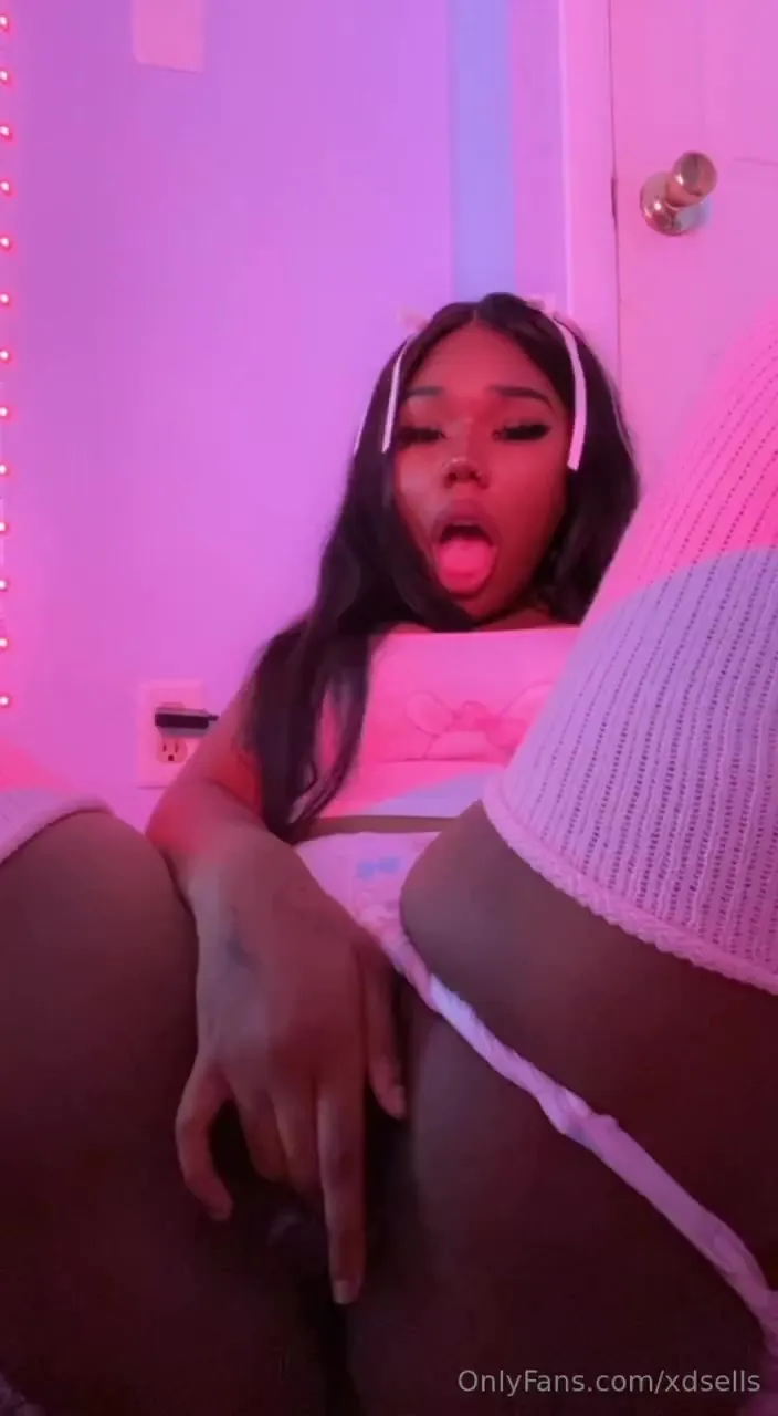 Pink-lit bedroom, Nye Lt rubbing her soaked clit and flashing her tongue