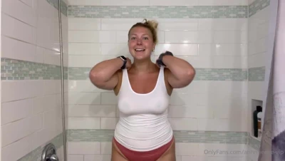 Peeling off her drenched top, Anne squeezes her heavy tits under the shower spray