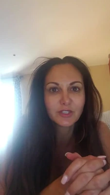 Ava Addams moans, hips twitching, as she leans forward with her legs spread wide