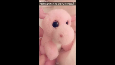 Rainy afternoon, Belle Delphine sprawls on the bed in black lingerie, playing with her pink dino plush