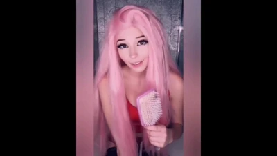 Belle Delphine toys with a brush in her red top, smirking like she knows exactly what she's doing