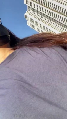 Rubbing herself through her denim shorts while strutting down the city street