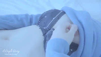 White bed, pale blue sweater, Carly finger-fucks her wet clit and pussy