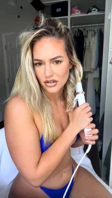 Riss primps in a blue bikini, powder, blush and a curling wand, all for the mirror