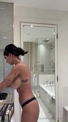 Mia Khalifa strips down in black lingerie and a gold bikini, then flashes her boobs for the selfie