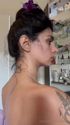 Buttoning up a white shirt, Mia Khalifa flashes her tits and tattooed back