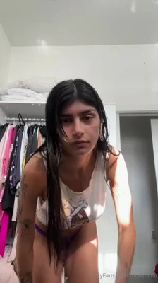 Mia Khalifa in a tee and purple panties, damp hair dripping down her neck
