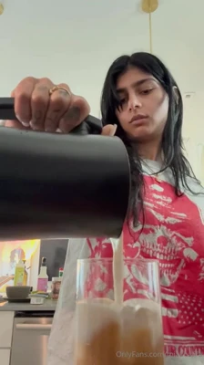 Mia Khalifa lifts her grey shirt to flash the thong, grinning as she shows off