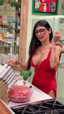 In a plunging red dress, Mia Khalifa blends a pink drink and strips down to heels