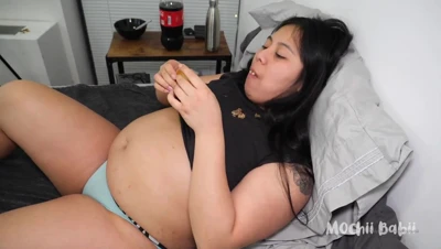 Mochii Babii feasts on a loaded sandwich in bed, baring her stretched belly
