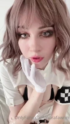 Posing in a nurse dress and gloves, Nora Fawn teases her curves on the sheets