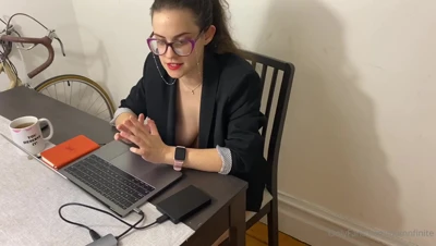 Leaning over her desk in a black blazer, Quinn Finite flashes a wicked grin and checks her watch