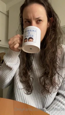 Sipping coffee and flashing a wicked smirk, Quinn Finite lets her wet curls spill everywhere