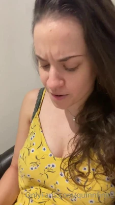 Leaning back and grinning while Quinn Finite lets her big tits spill from a yellow floral top