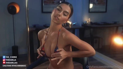 In a colorful string bikini, Thecheriemag squeezes her tits together and grins